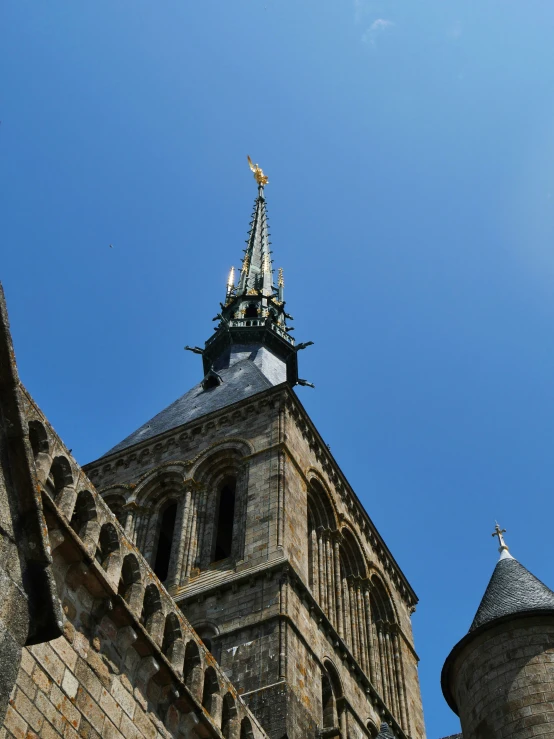 a tall clock tower with an iron cross on it's side