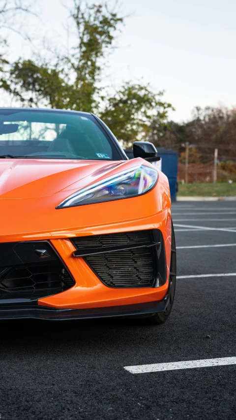 a bright orange sport car in an empty parking lot