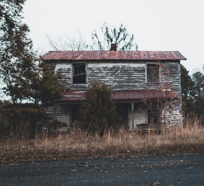 the worn and faded building is abandoned in the wilderness