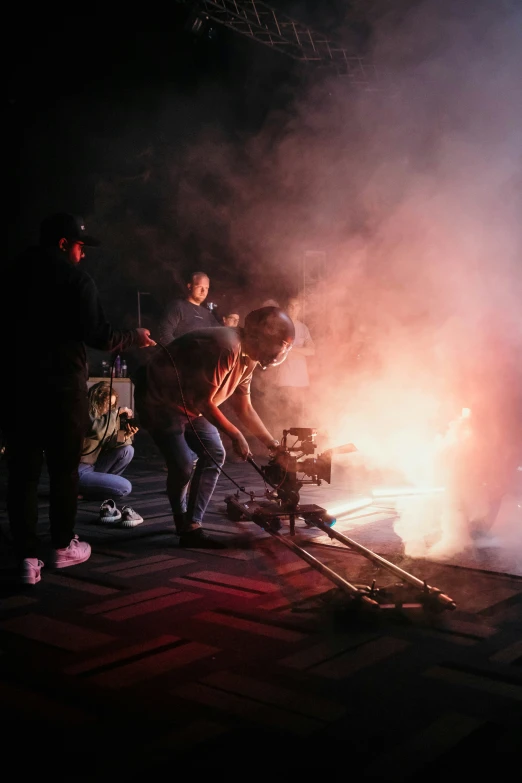 three men lighting soing on top of a stage