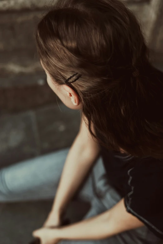 a woman sitting on the ground holding onto a teddy bear