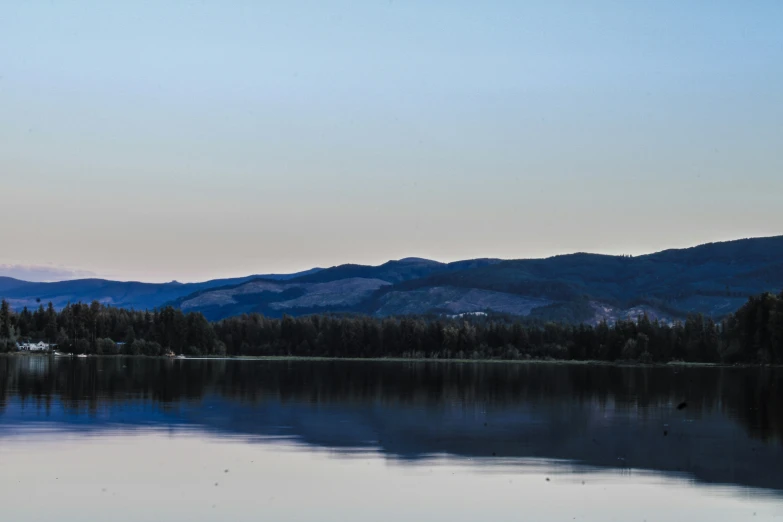 a view of the mountains and trees as seen from the water