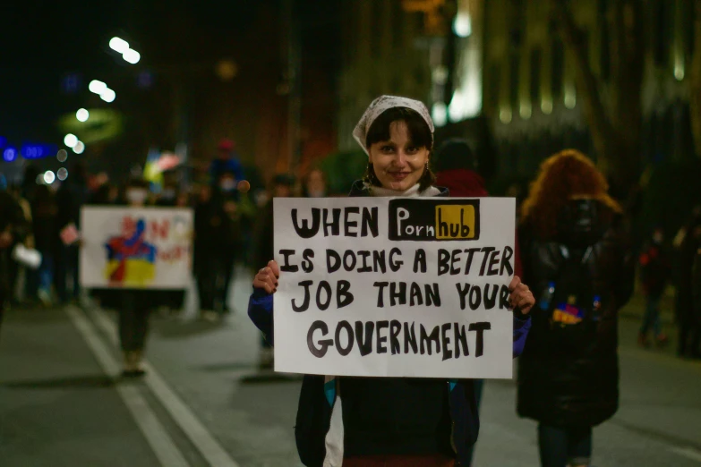 a protester holding up a sign stating it is a better job than your government