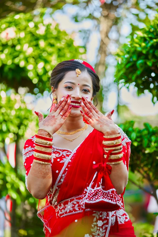 the indian girl is dressed in red and gold