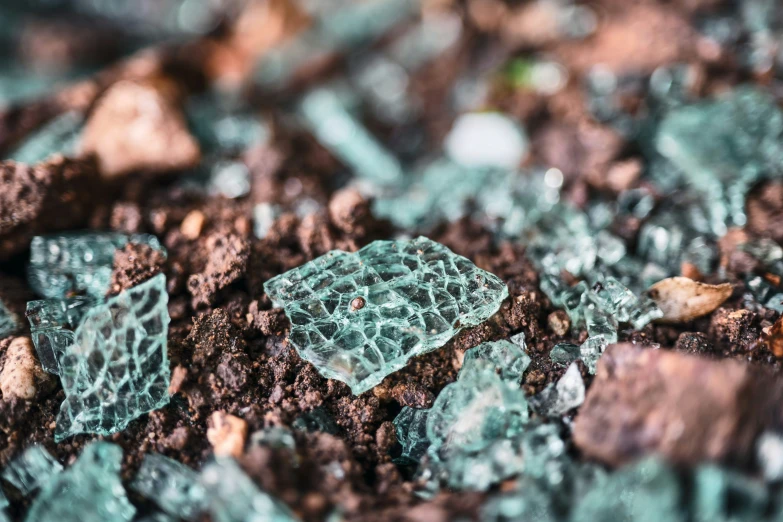 small chunks of glass sitting on top of dirt