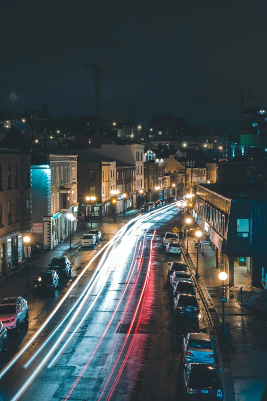 cars drive past the city street at night