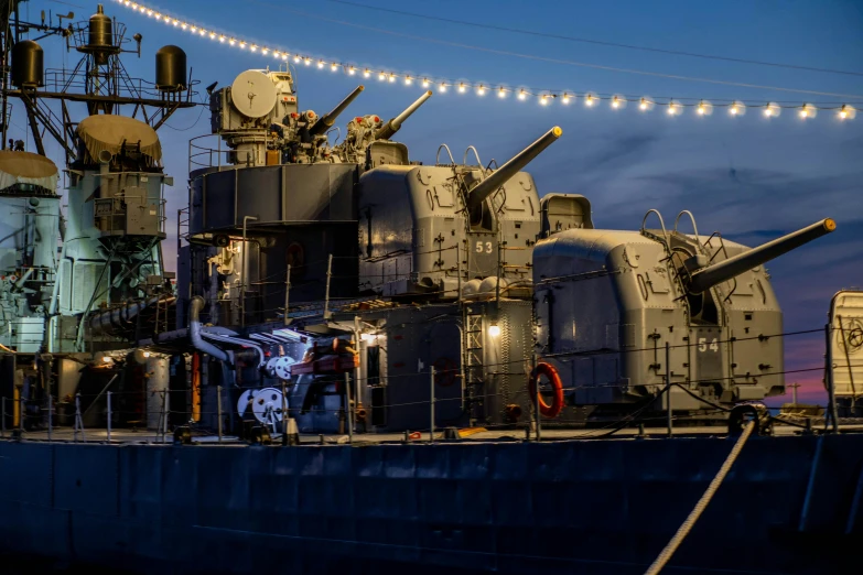 a large navy ship on dry dock at night