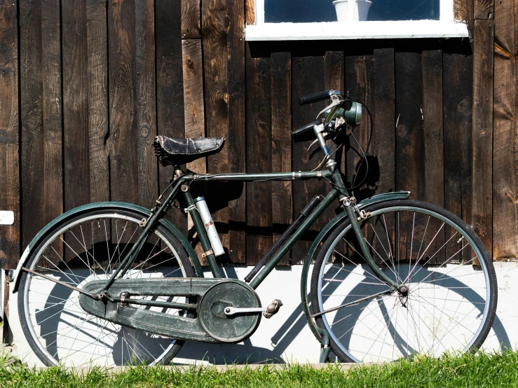 a bicycle parked in front of a wooden wall