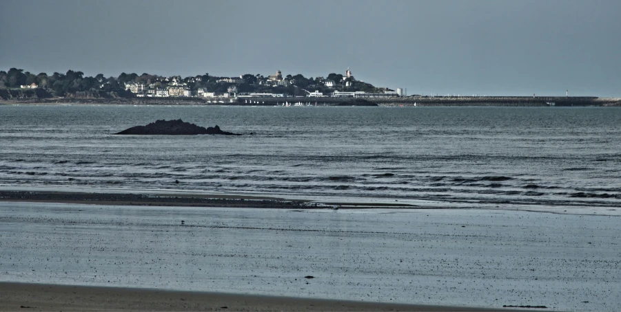 a lone boat out on the water next to a town