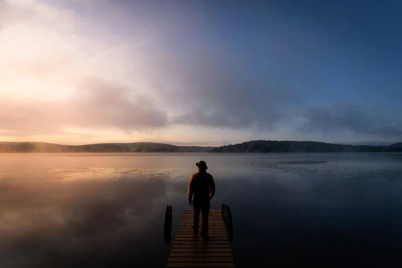 the person is standing on the dock alone