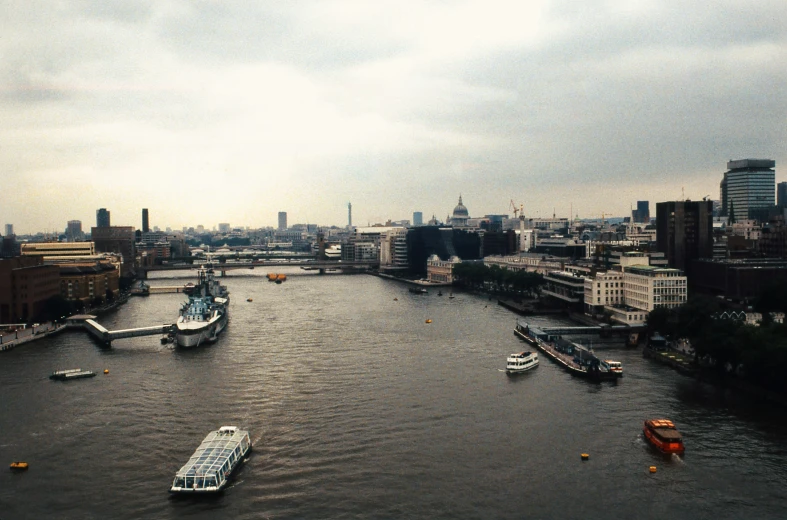 a wide river with boats on it passing through a city