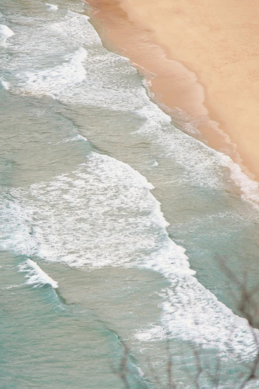 a view of waves in the ocean with people riding boards