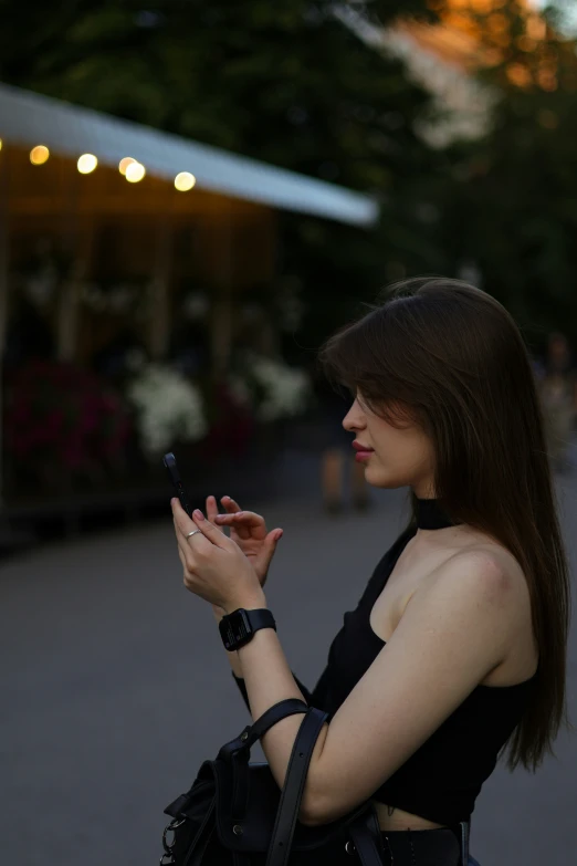 a woman standing next to a flower shop using her cell phone