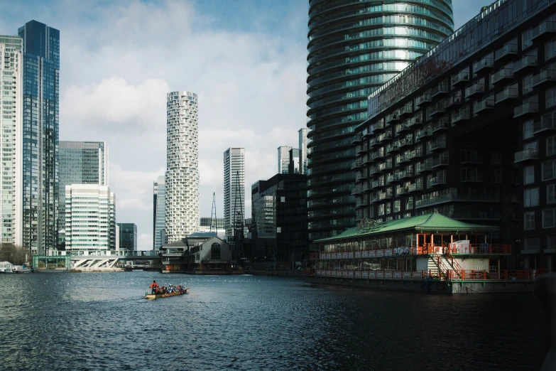 some tall buildings in the distance and a boat on a river