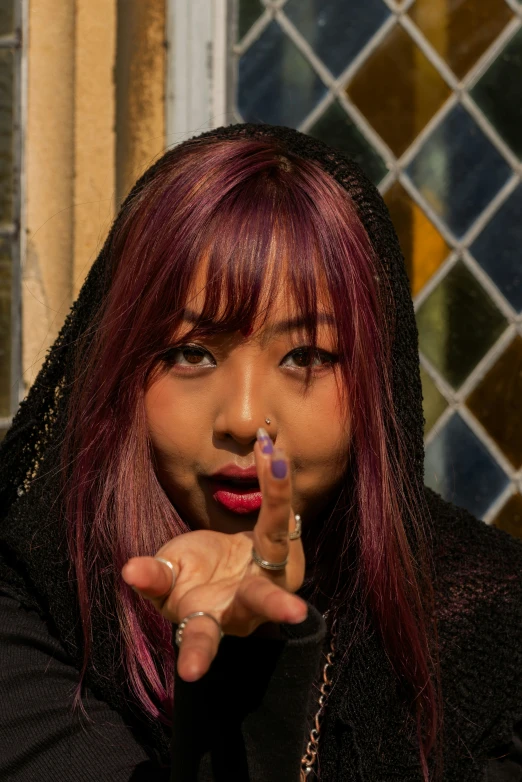 woman with ring and lipstick holding up a cigarette