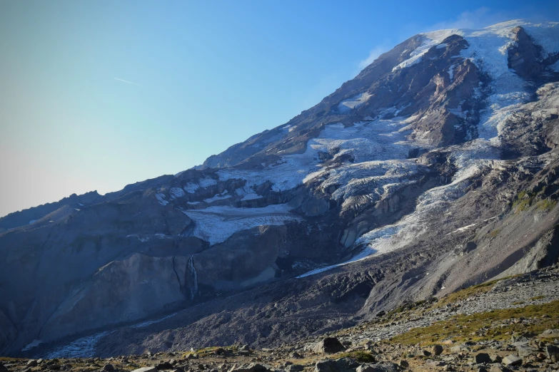 a view of some very snowy mountains from a small rocky area