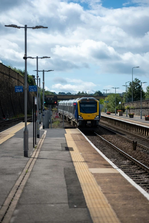 a train pulling into a train station next to an empty platform