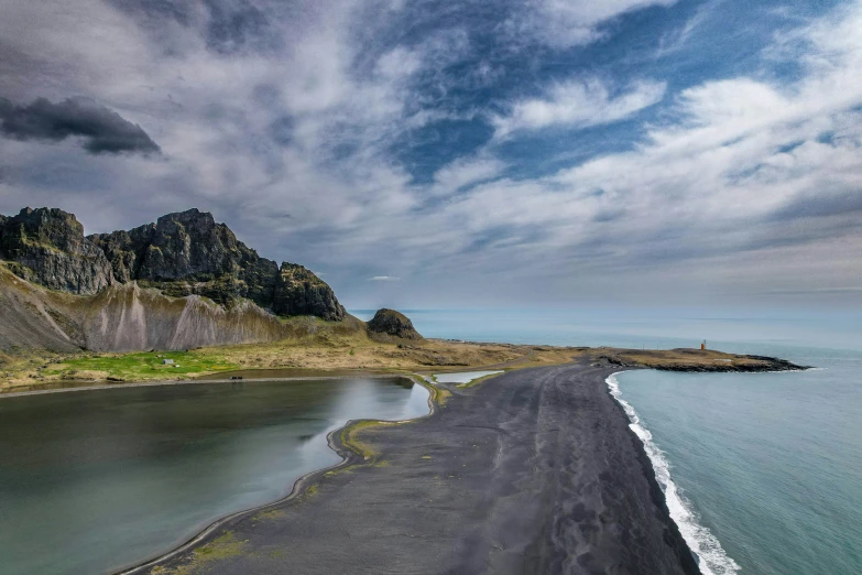 an empty beach and a grassy hill near the ocean