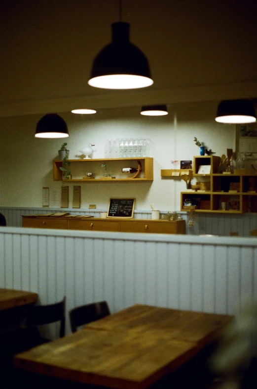 a restaurant with a counter and lights hanging over it