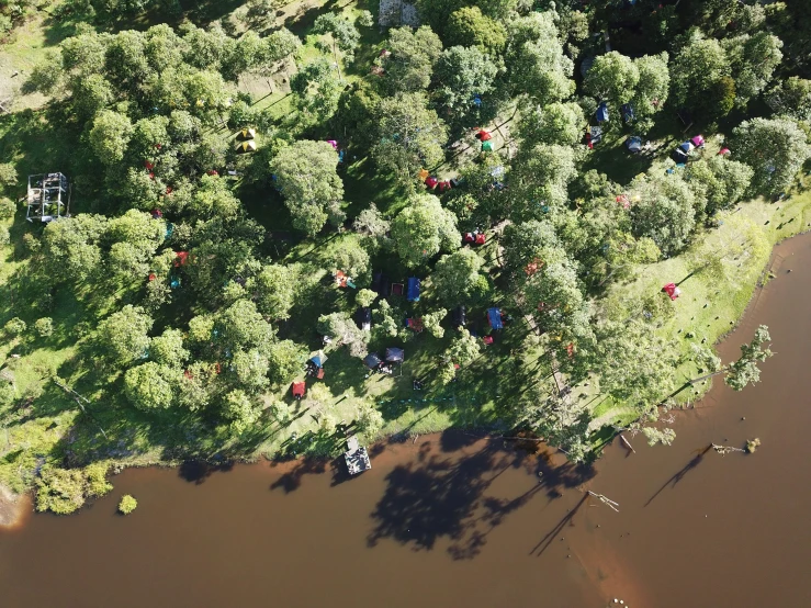 an aerial view of people camping near the river