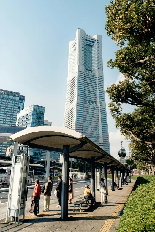 a city bus stop with a tall white building