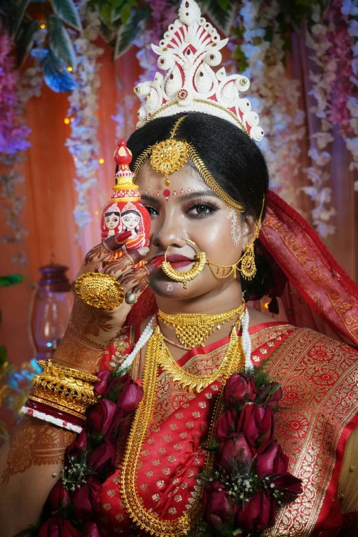 a bride holding her idol doll with her face painted