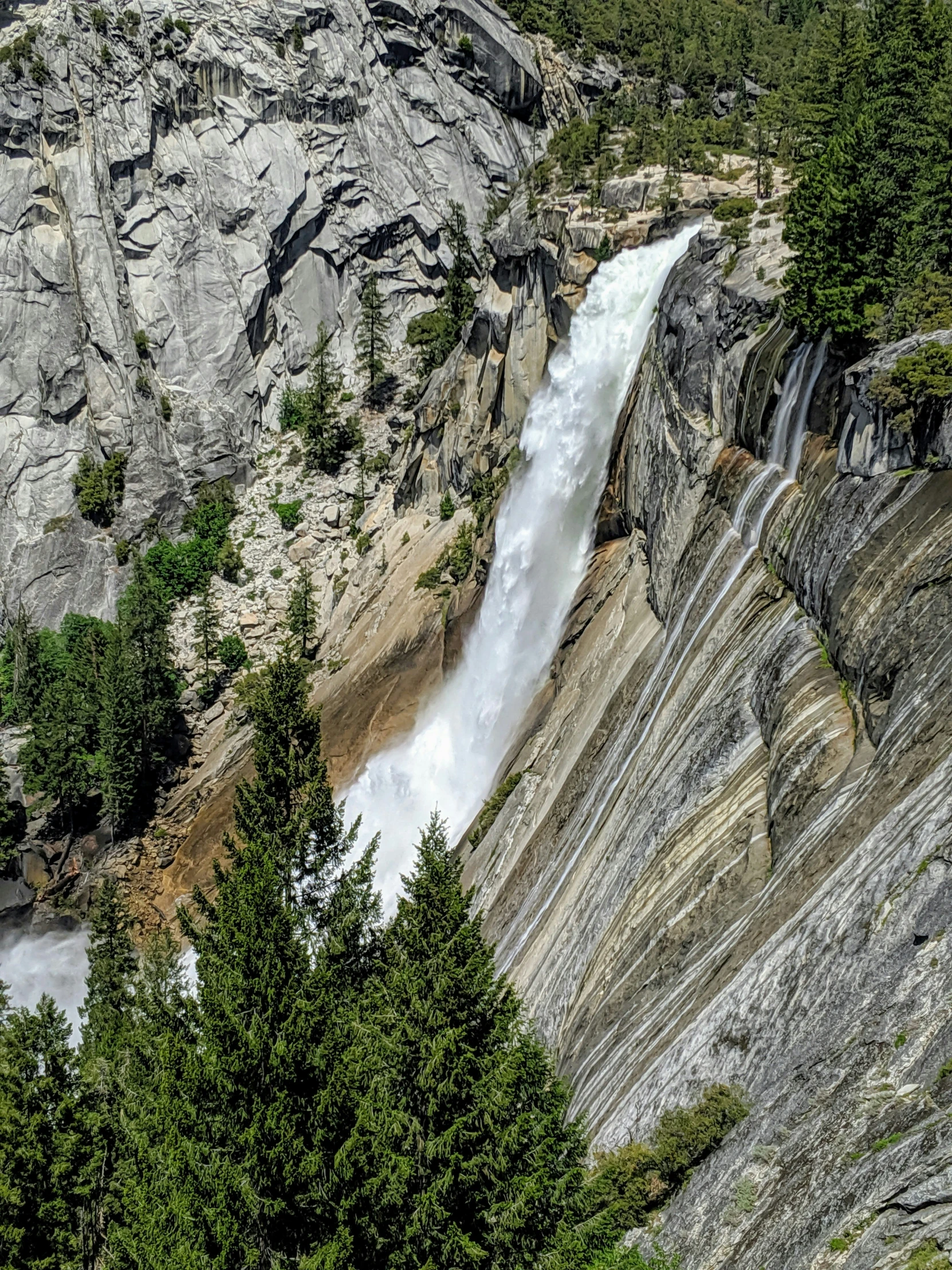 a waterfall and trees surround a mountain area