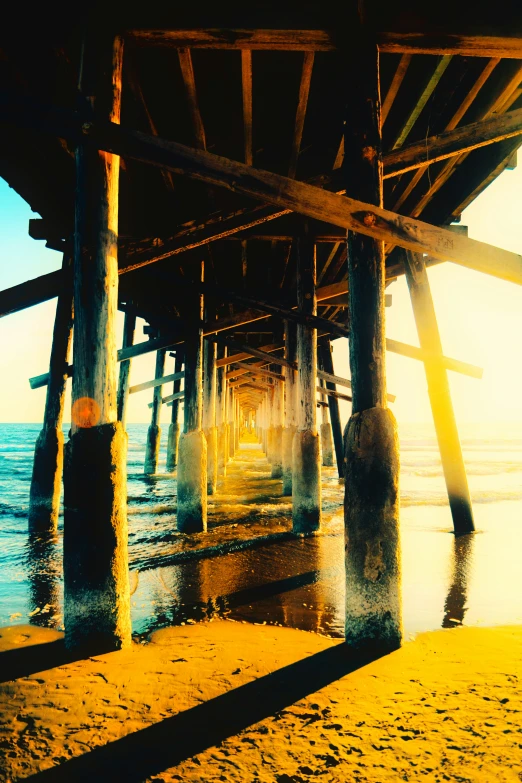 pier under water at a sandy beach with waves