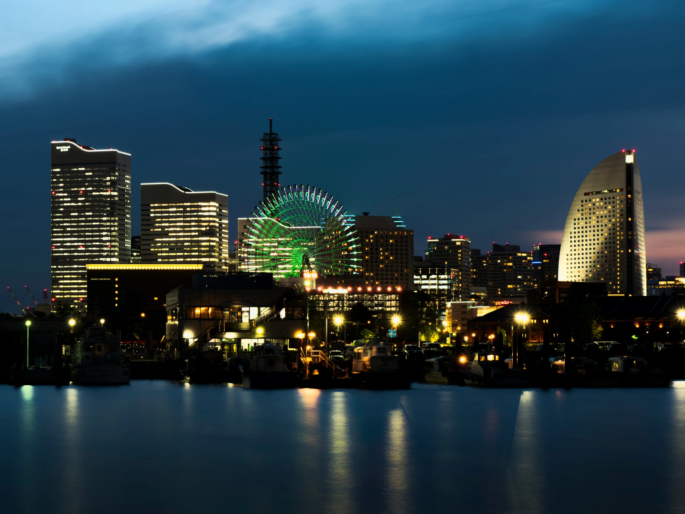 a city with buildings and a ferris wheel at night