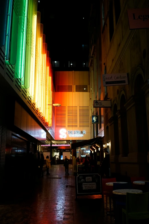 a brightly lit street with people walking by