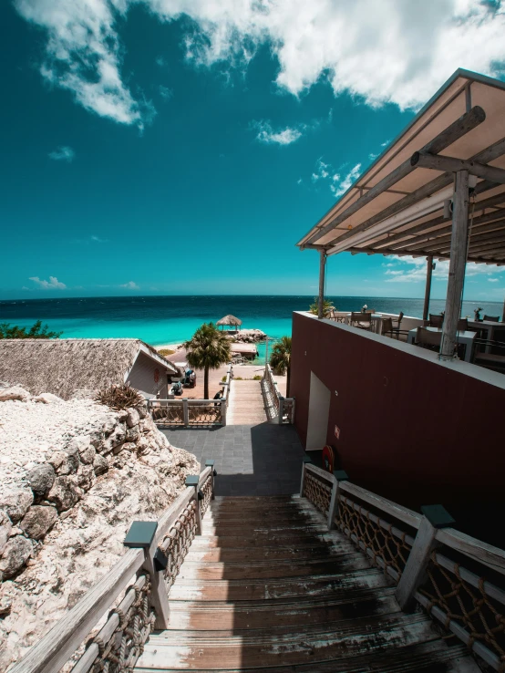 steps lead up to a beach area next to the ocean