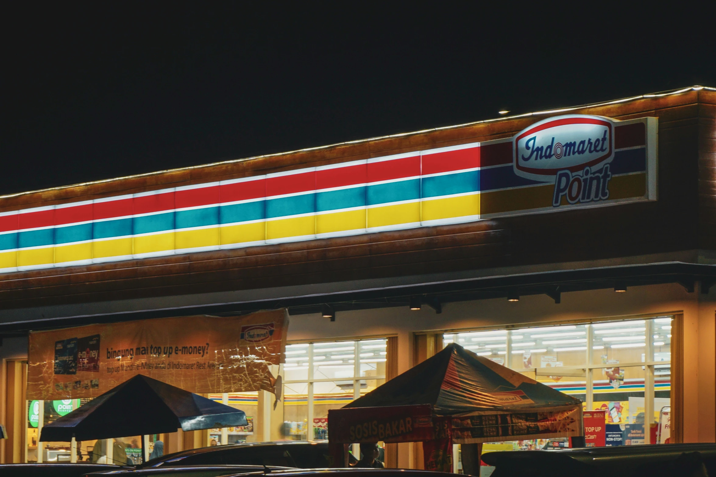 an outside view of a deli restaurant with lights on