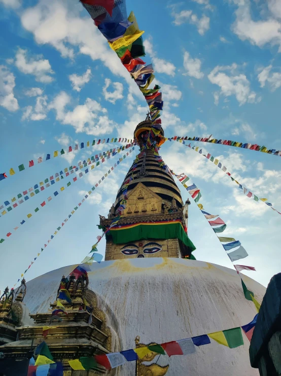 a large spire of a buddhist temple in the middle of some smaller stuiigns