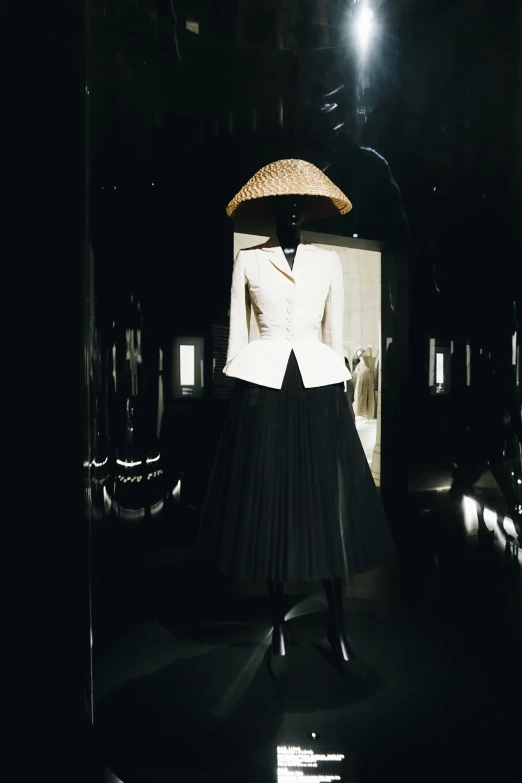 a fashion po from the 1950s with a black skirt and white top with the back turned towards the camera