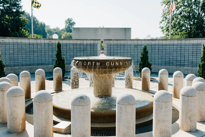 a fountain with words on it surrounded by smaller pillars