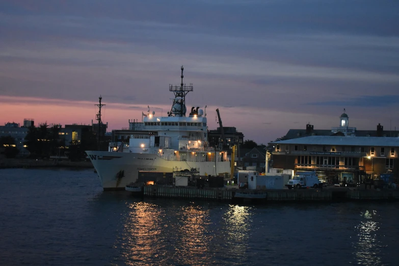 a large boat in the water next to a pier