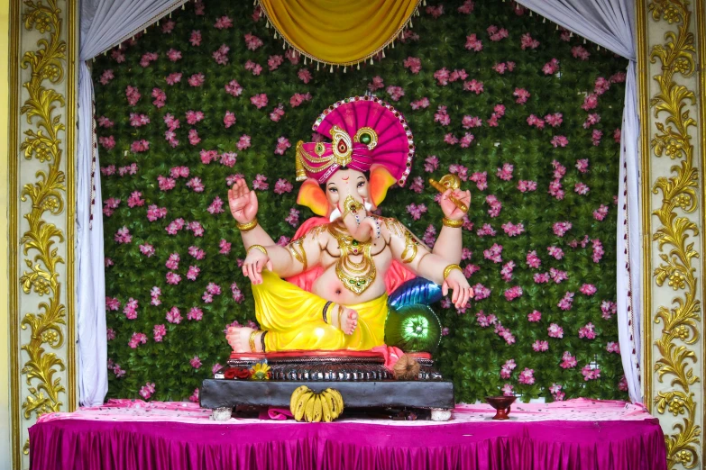 an idol standing in the middle of a table with flowers