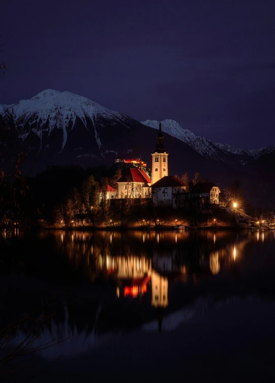 the small church is located at night, next to a body of water