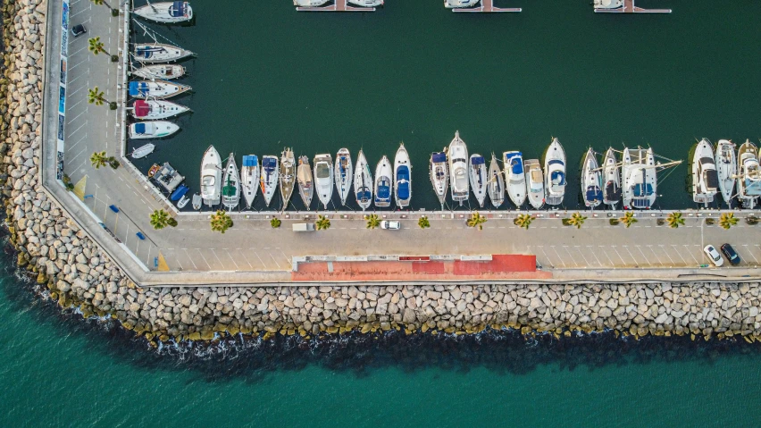 an aerial view of many small white boats near a dock