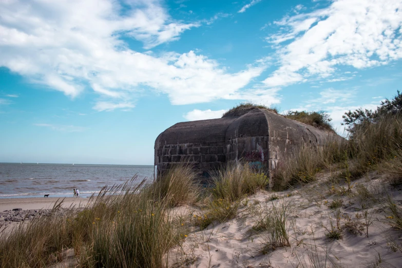 a rusted out building on a beach near the ocean