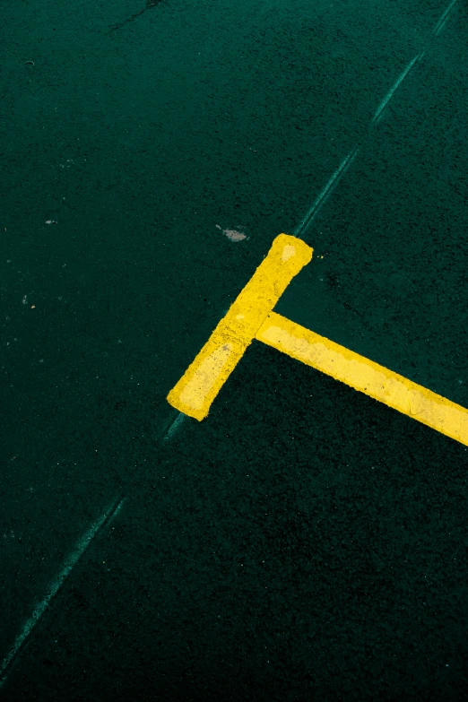 a yellow diagonal painted on the ground on asphalt