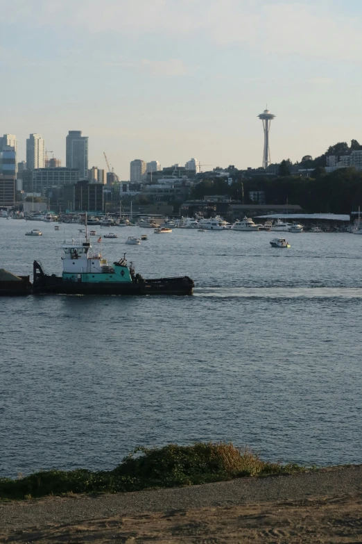 a tug boat is moving through the water near the city