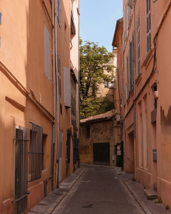 an empty street in a city with pink walls