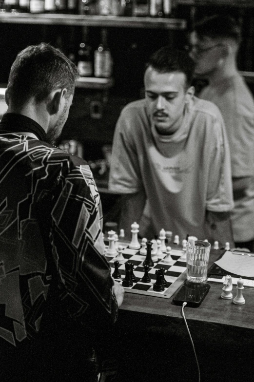 a chess game with three men, one playing
