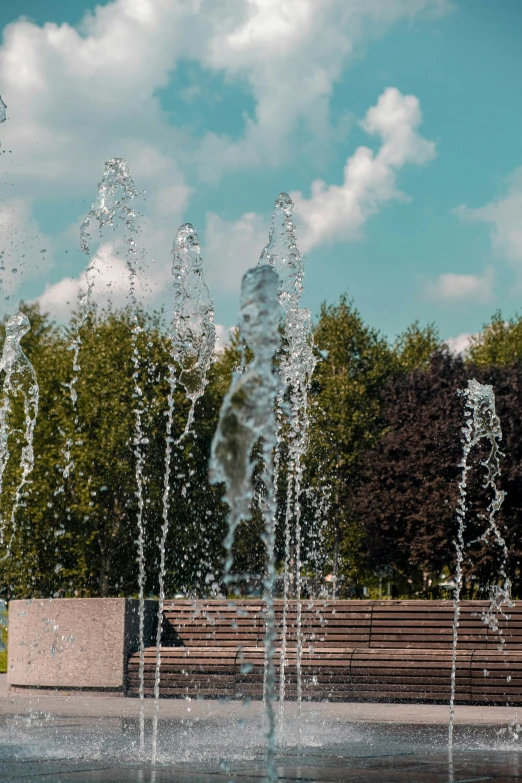 a water fountain near a park bench