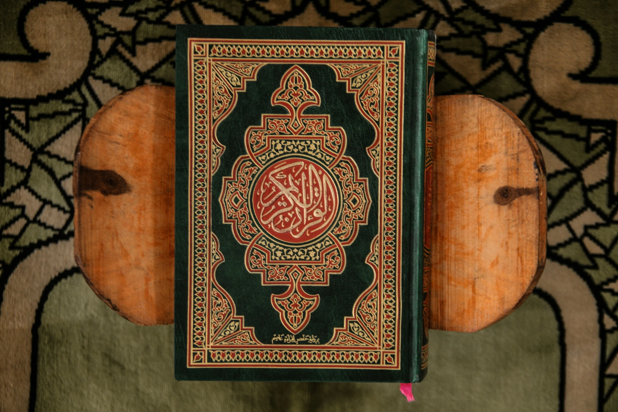 a islamic book laying on top of a wooden panel