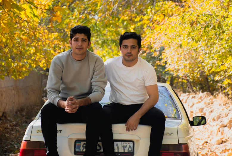 two men sitting in the back of a car