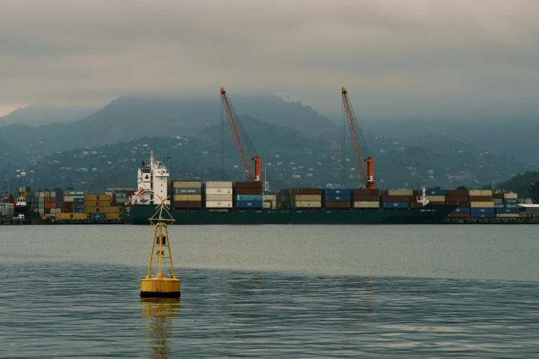 a tug boat is sitting near a harbor with cranes