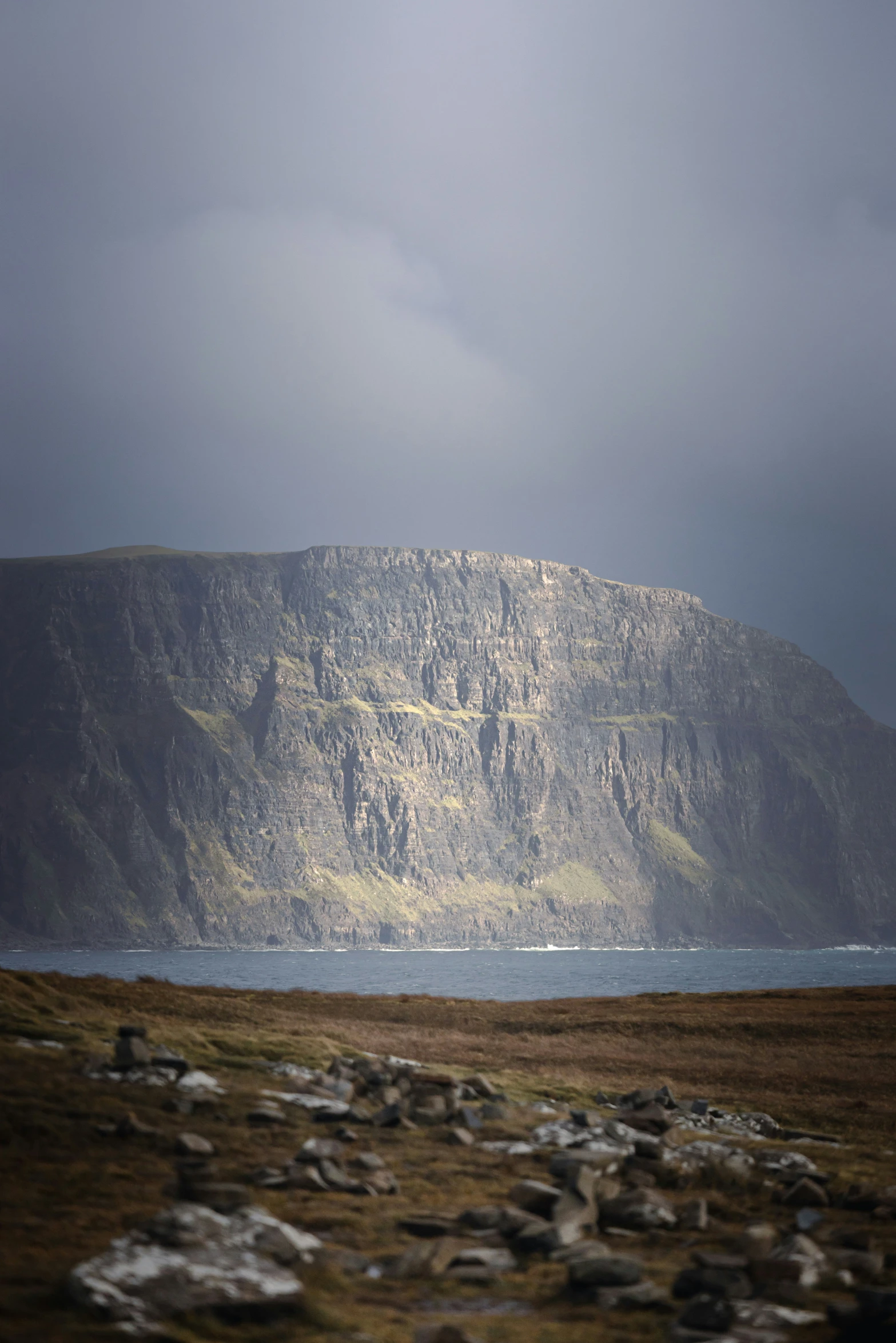 a large mountain sitting next to the ocean