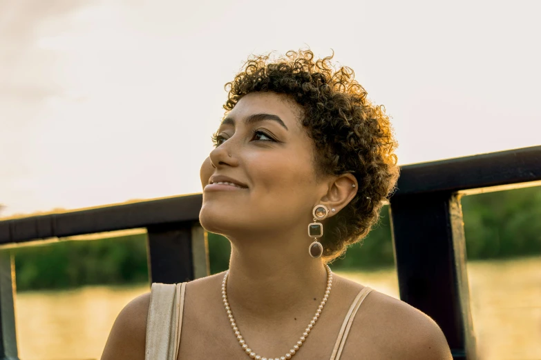 a woman with large earrings is looking up at soing